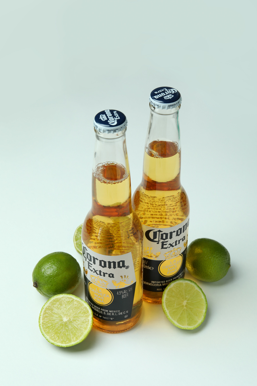 Bottles of Corona Extra and Limes on White Background
